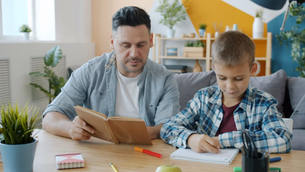 Father and son are drawing pictures and reading books