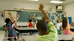 Student raising their hand in a classroom